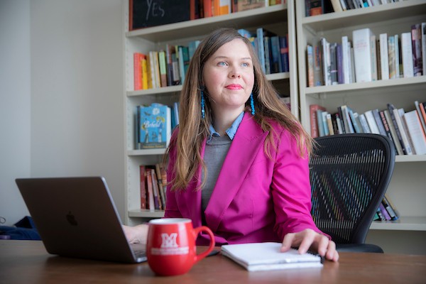 A teacher and mentor at her desk with a laptop ready to guide students