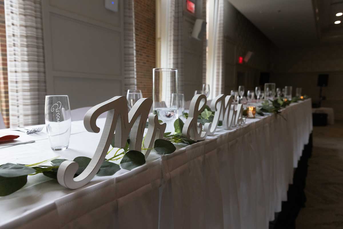 a wedding head table set for dinner with a Mr. and Mrs. sign